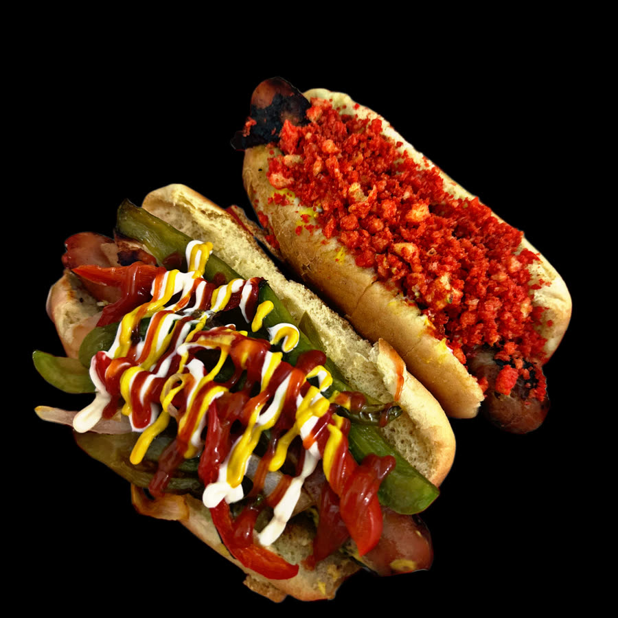 Two loaded bacon wrapped street dogs photographed on black.