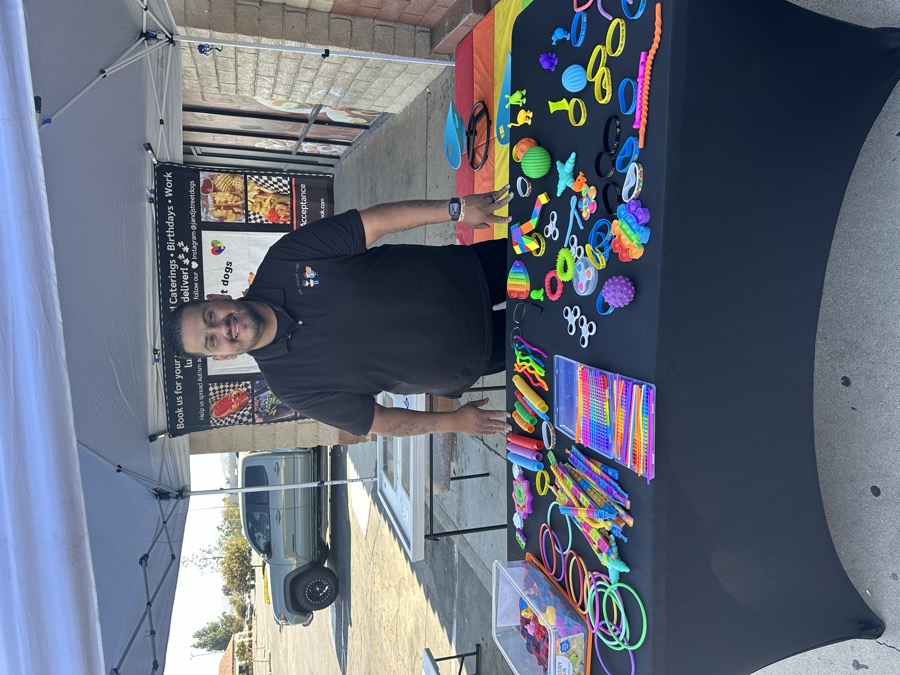 A table dressed with a serape runner and an autism awareness display.